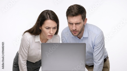 Two coworkers, a man and a woman, intensely focused on a laptop screen. Their expressions convey concern or concentration as they analyze the information displayed