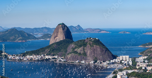 Foto The sweeping view of Sugarloaf Mountain highlights its imposing shape rising above Guanabara Bay, featuring green slopes, blue waters, and the sprawling city
