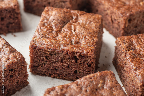 Photography Chocolate zucchini brownie squares close up on white textured background