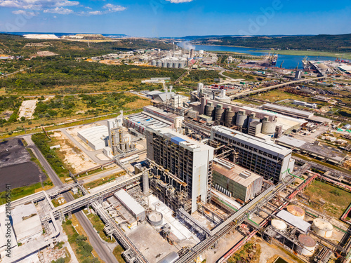 Fotografía View of industrial complex located near a river surrounded by green land and mou