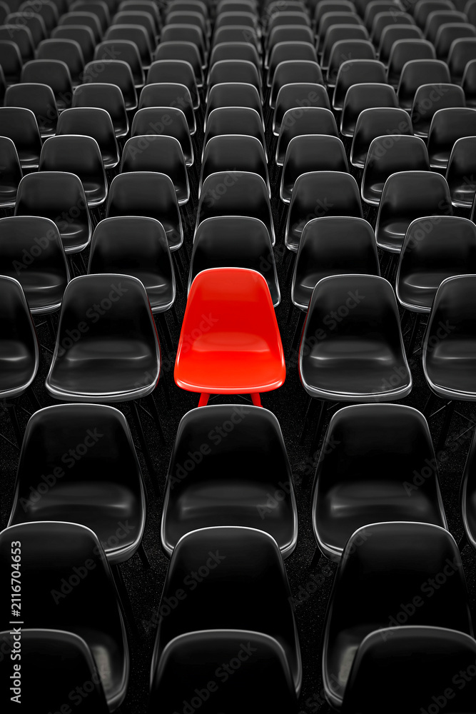 Fototapeta premium Bright red plastic chair standing out in a row of empty black seats. Leadership, uniqueness and individuality concept background in minimalist corporate or conference hall style