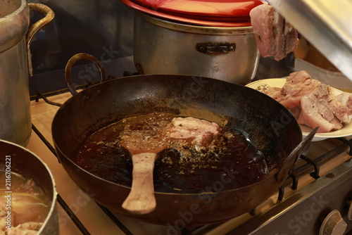 Pork meat cooking in hot lard for traditional Peruvian chicharrón