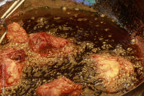 Pork meat cooking in hot lard for traditional Peruvian chicharrón