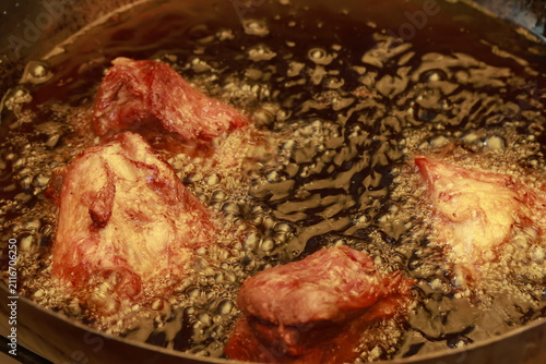 Pork meat cooking in hot lard for traditional Peruvian chicharrón