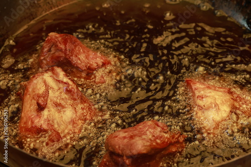 Pork meat cooking in hot lard for traditional Peruvian chicharrón