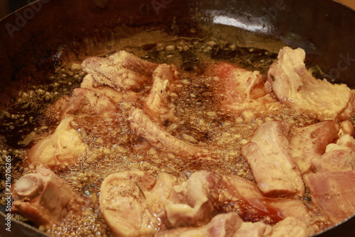 Pork meat cooking in hot lard for traditional Peruvian chicharrón