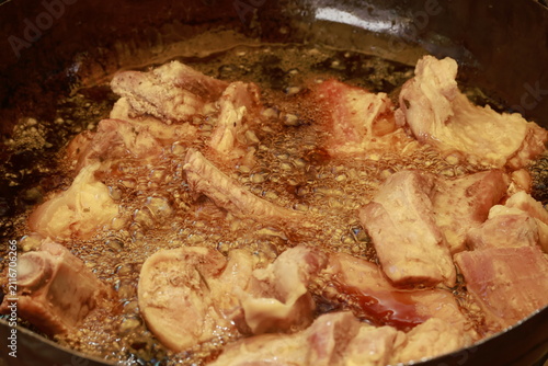Pork meat cooking in hot lard for traditional Peruvian chicharrón