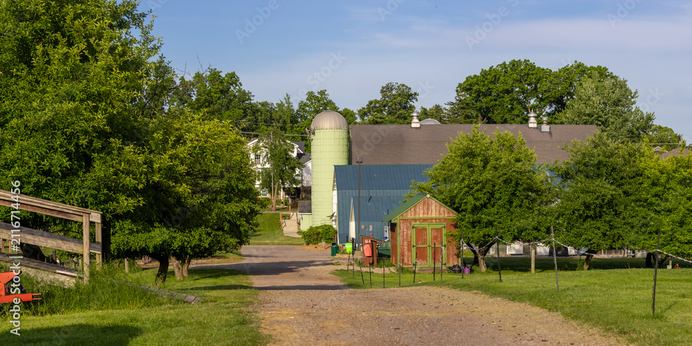Obraz premium Rural farm with green silo and outbuildings