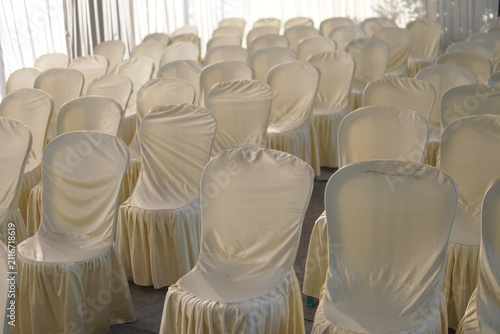 Canvas Print Rows of elegant empty chairs with white fabric covers arranged for a wedding ceremony or event