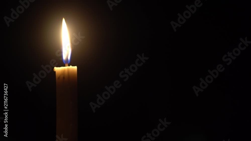 Calm Candlelight Flame Burning Quietly against Black Background