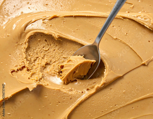 Creamy Peanut Butter in a Jar with a Silver Metal Spoon Scoop Top View