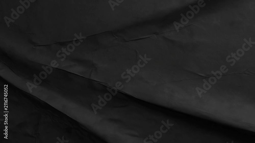 High resolution close-up of dark black crumpled paper surface with organic folds and soft dramatic lighting, perfect for modern design mockups or minimal aesthetic projects.