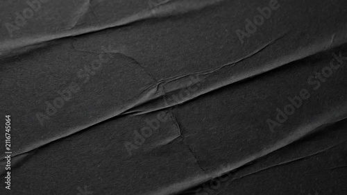 High resolution close-up of a matte black paper surface featuring dramatic diagonal creases and folds. Ideal for modern minimalist graphic design, artistic overlay textures, and moody aesthetic