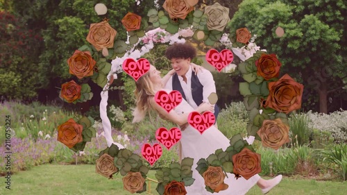 Couple embracing in floral hoop, starting roses and neon LOVE YOU hearts, dancing for wedding