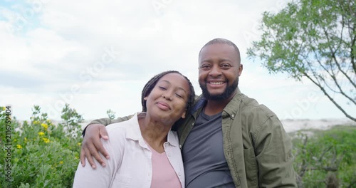 African American couple exchanging glances, leaning, showing love on dunes, shrubs, facing camera