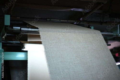 Industrial textile machine processing a wide fabric roll