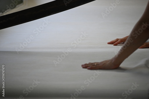 Hands inspecting fabric during textile production