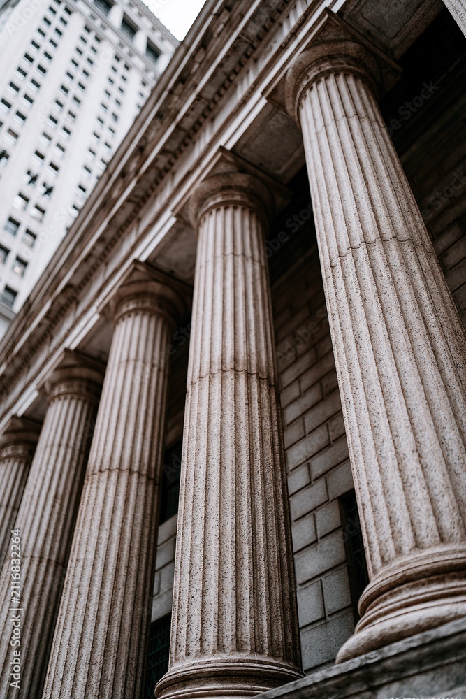 Obraz premium Grand Doric Columns of Classic Architecture Against a Modern Skyscraper Facade