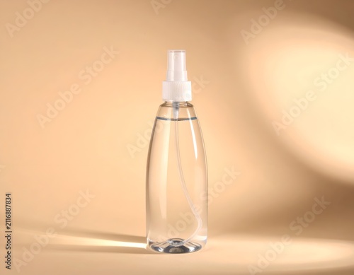 Clear Plastic Spray Bottle with Liquid on Minimalist Beige Background