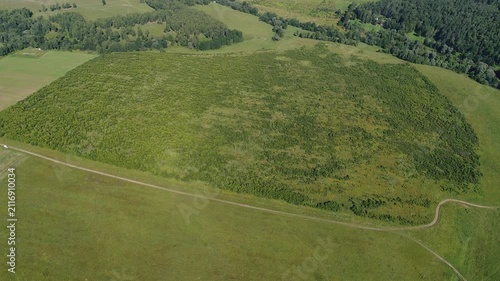 Smooth forward flight over green mound