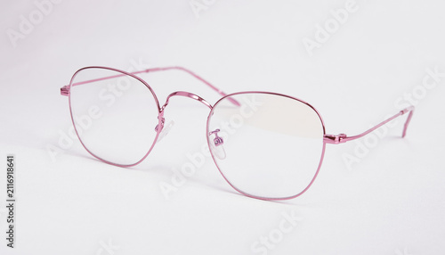 Pink metal eyeglasses isolated on white background with clear lenses