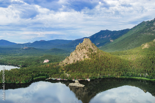 Panoramic view of Burabay Borovoe Lake and beautiful mountain Okzhetpes and rocky island Zhumbaktas, cloud blue sky. Burabay National Nature Park in Republic of Kazakhstan. Summer scenery landscape.