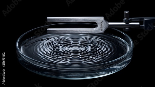 A vibrating metal tuning fork creates intricate standing wave patterns in liquid, a powerful metaphor for invisible resonance, harmony, and the tangible impact of subtle frequencies.