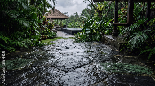 Rainy tropical garden path. Wet stone walkway leading to a luxury villa gazebo.