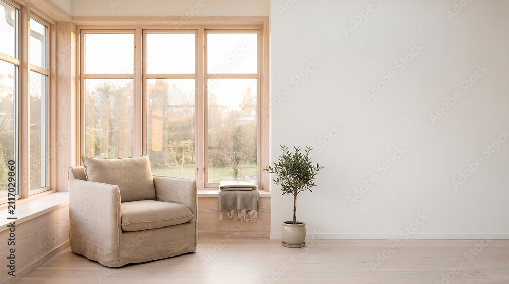 Fototapeta premium Serene sitting room with large windows armchair and olive tree plant