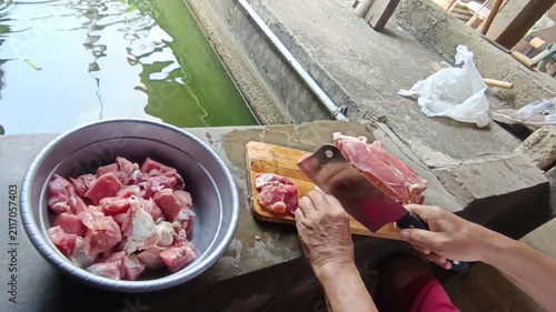Professional Video Footage of Butcher Carefully Cutting Fresh Raw Meat on a Wooden Cutting Board for Culinary Preparation and Food Industry Concept