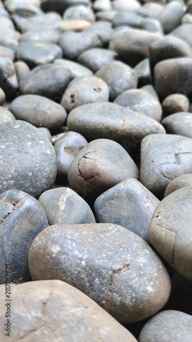 Fotografía Close-up shot of smooth gray river stones and pebbles arranged naturally, creating a calming and textured background for wellness, spa, and zen themes