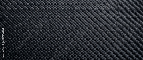 Close-up of a sleek, dark black carbon fiber texture with a detailed woven pattern, ideal for high-tech, industrial, and modern design backgrounds