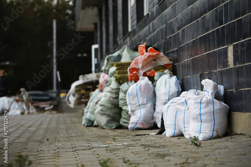 Konstfotografi Industrial Waste Bags Lined Against Brick Wall in Urban Setting