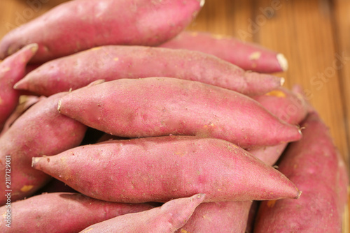 Obraz na płótnie Fresh Pink Sweet Potatoes on Wooden Surface