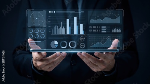 Hands holding a digital tablet with business data charts and financial analytics