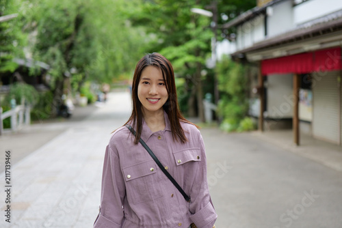 東京のレトロな観光地（深大寺近くの公道）を散策する女性のポートレート