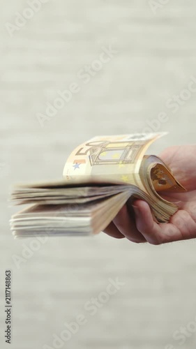 One hand flipping pack of money banknotes in slow motion