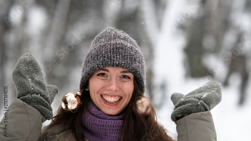 Konstfotografi A beautiful young woman in winter clothes is happily spending her free time in a snowy forest