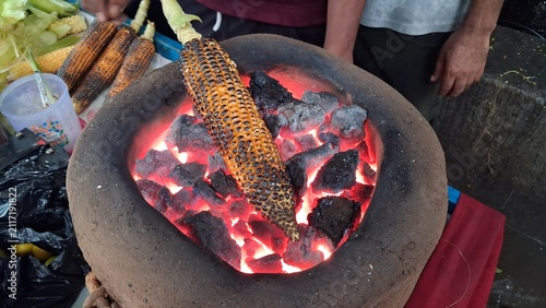 Konstfotografi Roasting fresh raw corn over a charcoal fire,Roasted corn is a delicious and healthy snack