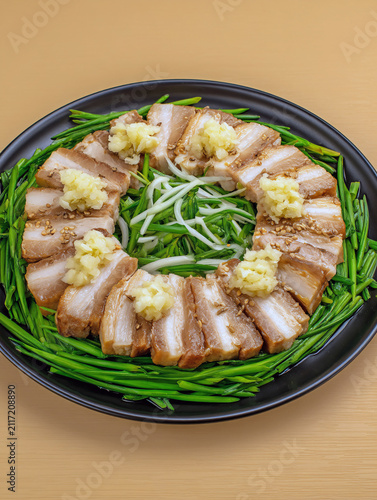 Delicious pork belly chashu with ginger and garlic on a black plate