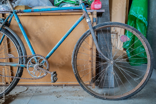 Blue vintage bicycle frame with rusty chain and pedals.
