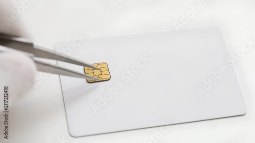 Sim card microchip smart card white plastic card chip electronic circuit closeup with tweezer technology security data communication identification