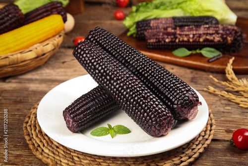 Obraz na plátne Fresh Black Sticky Sweet Corn Cobs Steamed and Ready to Eat on Rustic Wooden Tab