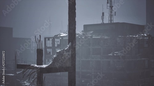 Closeup broken utility pole in foreground with rusted crossbeam and dangling cables, distant ruined blocks form hazy backdrop detailed texture shot ideal