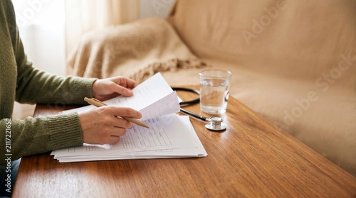 Hands-on review of documents, with a pencil in hand, a glass of water on the side, and the focused attention on the text.