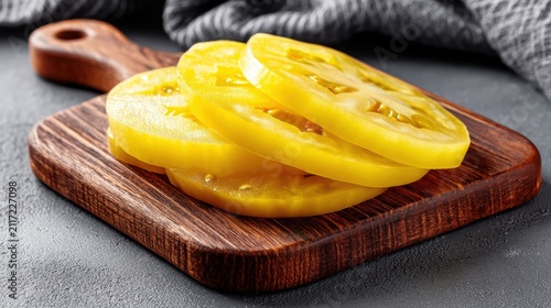 A wooden cutting board with sliced tomatoes on it.