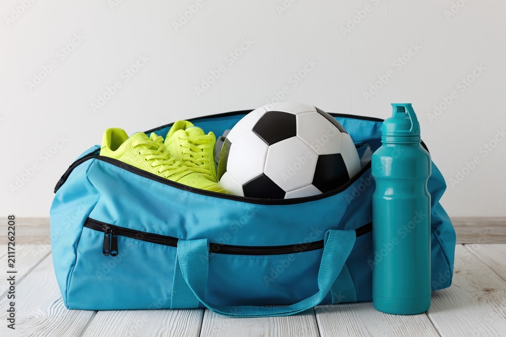 Fototapeta premium The Blue Duffel Bag with Soccer Ball and Neon Shoes for Training