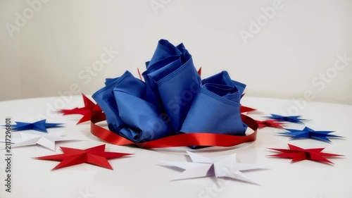 Elegant patriotic table setting with blue folded napkins and red white star decorations for a celebration