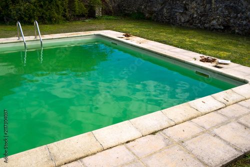 Foto Starting the spring clean up of dead leaves and green algae in a swimming pool neglected over the winter