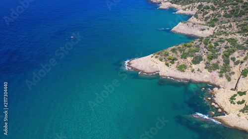 Aerial drone  of a peaceful beach in Thassos, Greece, featuring transparent turquoise water, paddleboards, swimmers and a beautiful Mediterranean coastline.